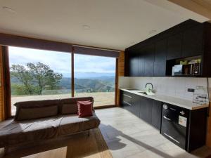 瓦尔帕莱索Mini casa en lo alto de la montaña的带沙发和大窗户的客厅