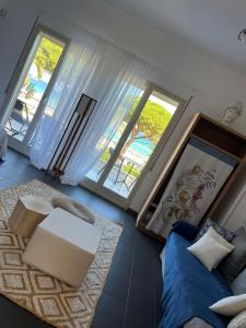 蒙德罗Villa Olimpia的带沙发和2扇窗户的客厅