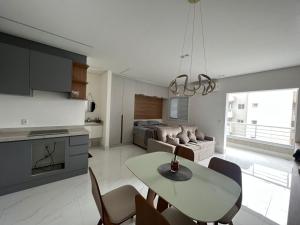 圣贝尔纳多-杜坎普Apartamento Studio em São Bernardo的厨房以及带桌椅的起居室。