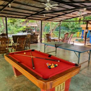 塔马林多Casa Pura Vida Surf Hostel - Tamarindo Costa Rica的一间设有两张乒乓球桌和椅子的房间