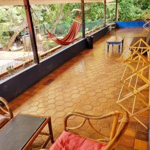 塔马林多Casa Pura Vida Surf Hostel - Tamarindo Costa Rica的客房设有吊床和桌椅。