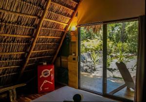Santa RosaCabinas de Lou Eco Lodge TAMARINDO的客房设有窗户,享有庭院的景致。