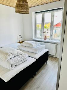 斯卡恩Skøn villalejlighed i Skagen med terrasse og tæt på centrum的带2扇窗户的客房内的2张床