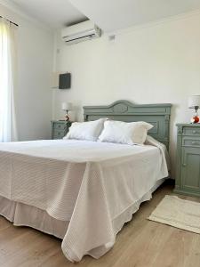 圣安东尼奥德阿雷科Los Narcisos的卧室配有白色大床和绿色家具