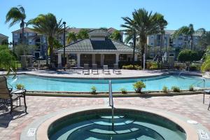 奥兰多Vista Cay Jewel Luxury Condo by Universal Orlando Rental的一个带椅子的大型游泳池和一个背景房子