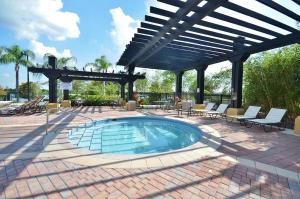 奥兰多Vista Cay Jewel Luxury Condo by Universal Orlando Rental的一个带椅子和凉亭的庭院内的游泳池