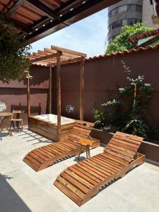 贝洛奥里藏特Espaço Nill的庭院设有两张木长椅和一张床