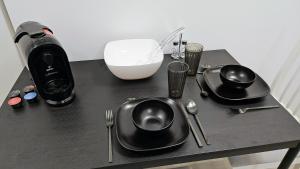 奥格斯堡Apartment Küche Arbeitsplatz Netflix WLan Barrierefrei的一张桌子,上面有黑色的盘子和餐具,还有搅拌机