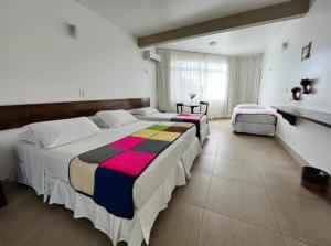 阿雷亚Hotel Fazenda Triunfo的一间设有两张床和窗户的大卧室