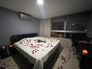 瓜亚基尔Five Stars Suites - Kennedy - Guayaquil的一间卧室,床上有红色的鲜花