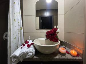 瓜亚基尔Five Stars Suites - Kennedy - Guayaquil的浴室设有玫瑰和蜡烛水槽