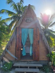 AmontadaEcocamping Lumiar的一间小小屋,拥有蓝色窗帘和棕榈树