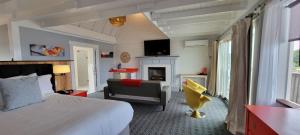 格洛斯特The Hotel at Cape Ann Marina的一间卧室配有一张床、一把椅子和一个壁炉