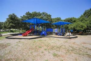 萨拉索塔Cozy Cottage near Beaches and Downtown Sarasota的一个带滑梯和蓝色遮阳伞的游乐场