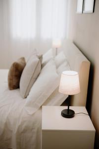 维罗纳Alatea Apartments Valverde的配有枕头的白色沙发以及带台灯的桌子