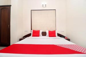 阿姆利则寺庙景酒店 的一间卧室配有一张带红色枕头的大床