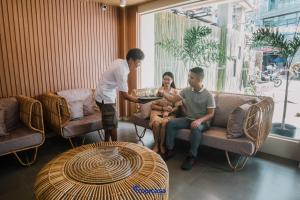 科隆Tropicasa Coron Resort & Hotel的一群人坐在一个房间里桌子上