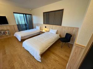 桑名市machiyado Kuwanajuku Edomachi 21的酒店客房,配有两张床和椅子