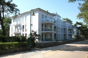 赛巴特班森Ostseeresidenz Gorki- Park - 23 mit Wellness und Schwimmbad的前面有路灯的白色建筑