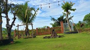 吉仙Sunny Eco Lodge的一个带栅栏、树木和草地的花园