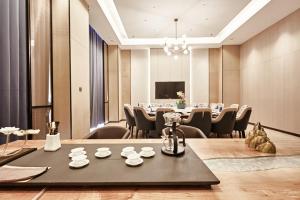 台州万斯国际酒店(临海杜桥店)的一间会议室,配有长桌子和椅子