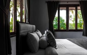 利巴诺伊Anahata Resort的卧室配有带枕头和窗户的床。