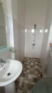 康提Smile Hub Kandy Penthouse apartment的白色的浴室设有水槽和淋浴。