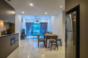 吉隆坡Eaton KLCC Suites By Elite的厨房以及带桌子和冰箱的用餐室