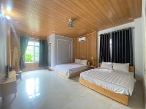 Bảo LạcBảo Lạc - Sunny Homestay的一间卧室设有两张床和木制天花板