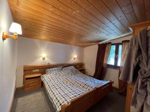 蒂罗尔-基希贝格Fleckalm Chalets的一间卧室设有一张床和木制天花板