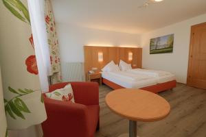 阿特湖Hotel Haberl - Attersee的酒店客房,配有床、桌子和椅子