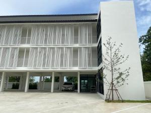 红统府IKKYU2 Angthong อิคคิว2的一座白色的建筑,庭院里设有停车位