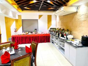 达卡Hotel West Valley Dhaka的一间餐厅,上面有红色鲜花桌