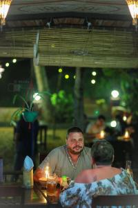 瓦尔卡拉Maadathil Cottages & Beach Resort的坐在桌子上的男人和女人