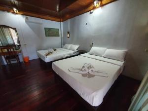 Ko PorFamily House的一间卧室配有两张带白色床单和装饰的床。