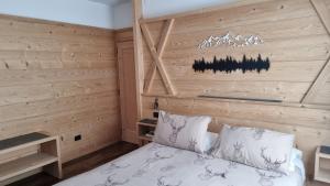 科尔蒂纳丹佩佐盖亚别墅酒店的一间卧室配有一张木墙床