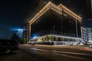 吉达Paradise Inn Jeddah Hotel的街上的一座大建筑,晚上有灯