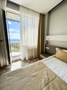 敖德萨12楼公寓酒店的一间卧室设有一张大床和一个大窗户