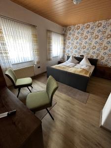 埃森斯加尔尼诺尔丁酒店的一间卧室配有一张床、一张沙发和椅子