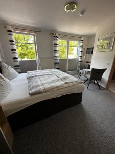 埃森斯加尔尼诺尔丁酒店的一间卧室配有一张大床和一把椅子