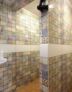 斯拉夫西克Рандеву的浴室的墙壁上设有瓷砖和淋浴。