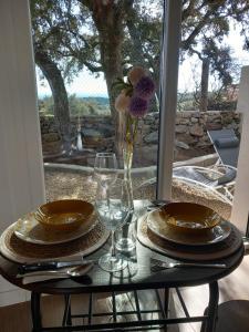 Hinojosa de San VicenteBungalow Sierra San Vicente的桌子,上面有盘子,玻璃杯,花瓶