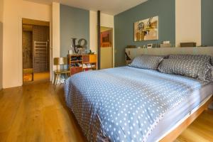 巴黎LOFT 11e près Canal St-Martin - Chambre climatisée SDB privée的一间卧室配有一张带蓝色和白色棉被的床