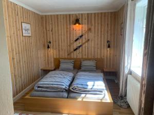 RamseleCozy Zweeds huis met openhaard en grote tuin的木墙客房的一张床位