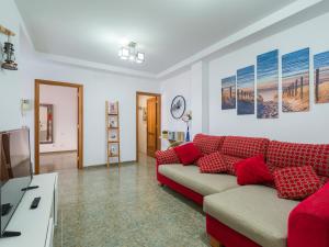 大加那利岛拉斯帕尔马斯Bluebeach的客厅配有红色沙发和电视