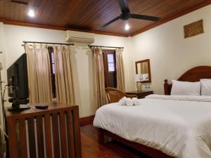 琅勃拉邦somvang khily guesthouse 宋旺吉利 酒店的一间卧室配有两张床和一台平面电视