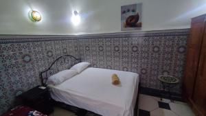 非斯达尔阿尔塔德莱酒店的一间小卧室,墙上设有一张白色的床