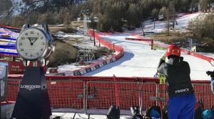 瓦勒迪泽尔Résidence Les Cîmes - Centre Val d'Isère的站在滑雪场上一个钟表旁的人