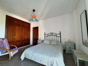 贝瑙卡斯apartamento arroyo的一间卧室配有一张床和一把椅子