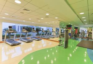 阿布扎比CozyCorner - Gym & Pool Access - Reem Island的一间健身房,里面设有一排跑步机和椭圆机